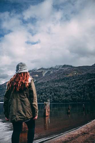 clothing brown haired woman in grey jacket and black leggings standing in beach coat