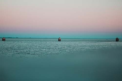 building calm sea under clear sky tower
