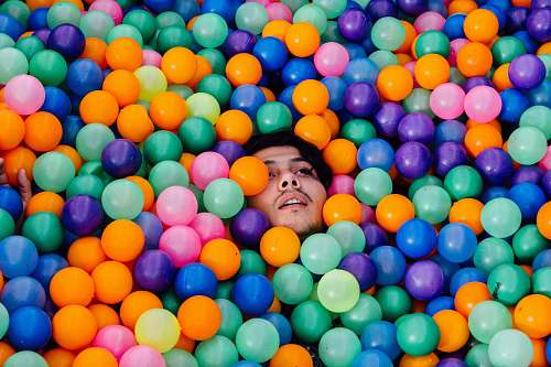 man man lying in ball pit balloon