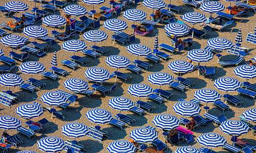 summer aerial photography of blue-and-white patio umbrellas sand