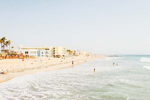 water beach near building at daytime sea