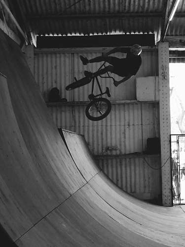 ramp grayscale photography of man riding bike machine