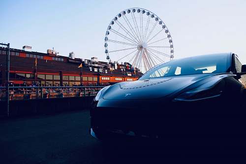 city black Tesla vehicle parked by building metropolis