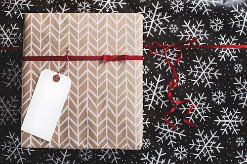 holiday gold and white gift box on white and black fair-isle print surface gift