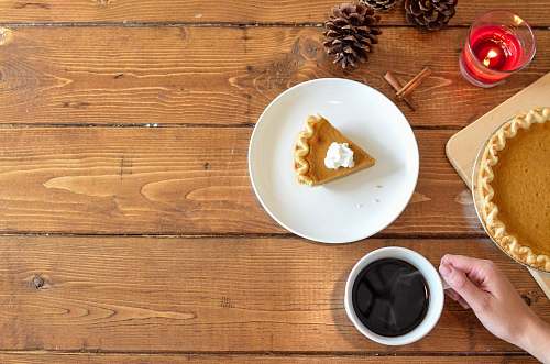 thanksgiving slice of pie with whipped cream on ceramic plate near coffee bowl