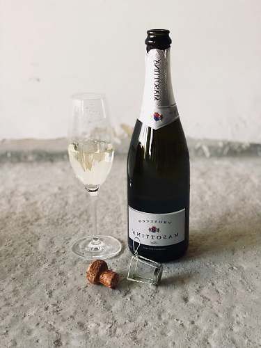bottle black champagne bottle beside champagne flute drink