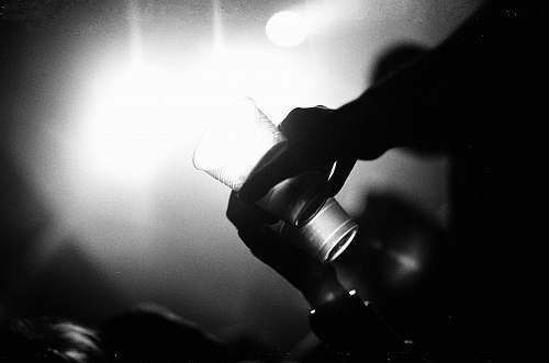 black-and-white grayscale photography of person holding drinking glass hand