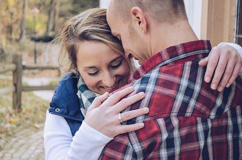 person man and woman embracing beside wall hug