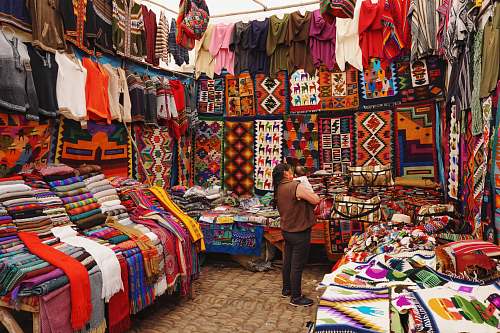 person woman in store with display of assorted shirts and textiles market