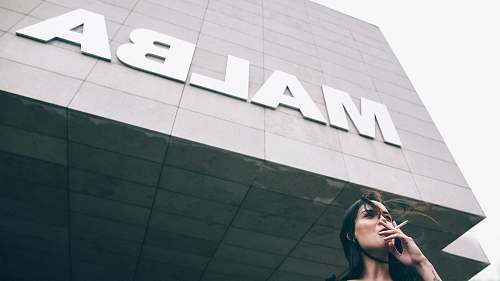 person woman taking cigarette near Malba building people