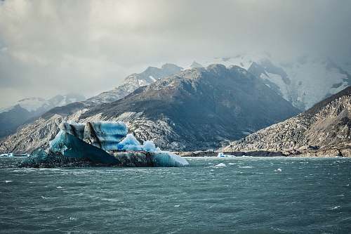 ice body of water near mountain during daytime glacier