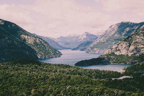 nature river in the middle of mountain under sky outdoors