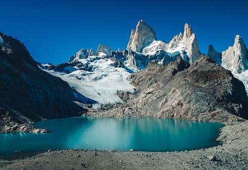 glacier snow covered mountain beside body of water snow