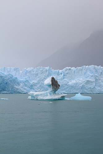 ice iceberg on body of water at daytime glacier