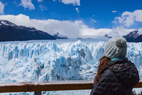 mountain person wearing black hooded jacket seeing snow mountain during daytime snow