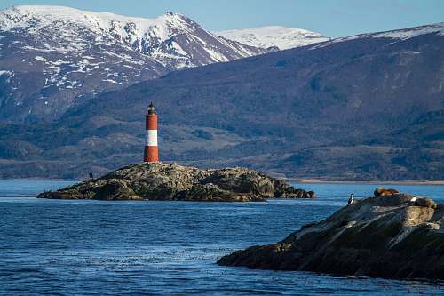 ocean red and white lighthouse on island sea