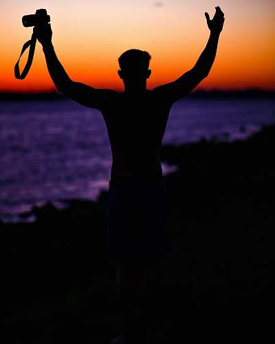 sunset person holding DSLR camera silhouette