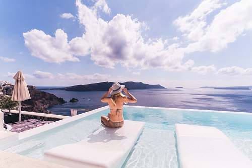 human woman sitting on white chair near body of water during daytime people