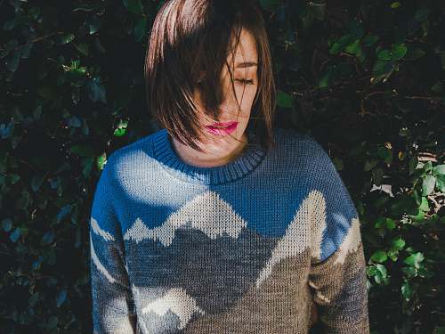 human woman wearing sweater near green grass wall people