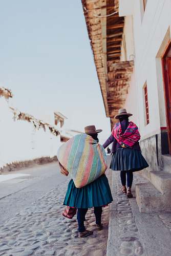 human two person carrying bags standing on gray concrete floor person