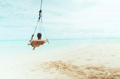 toy man swing beside body of water water