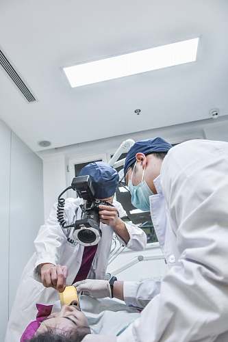 human two surgeon standing in front of patient lying on bed person