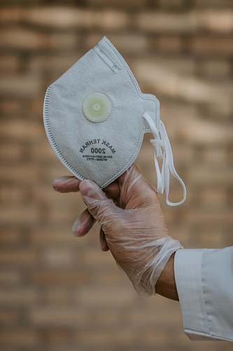 apparel person holding white and yellow cap clothing