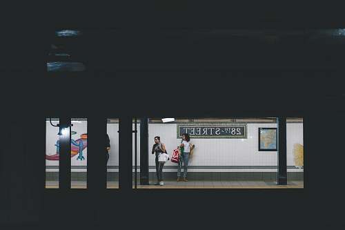 person two women standing on train station train