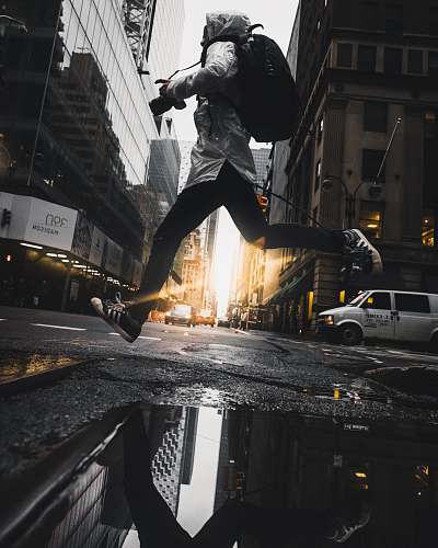 human person jumping above puddle of water people