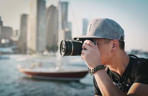 person man holding black DSLR camera people