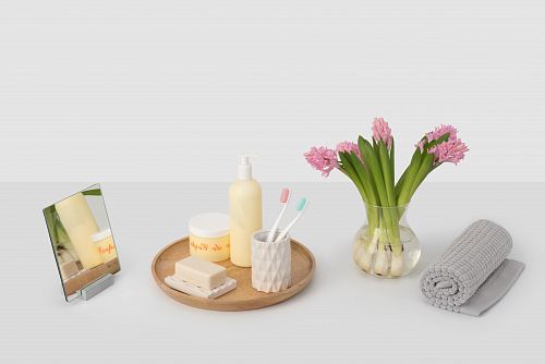 clear glass flower vase near rolled grey mat