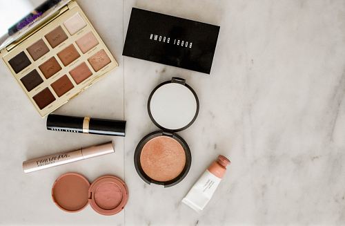 photo of assorted makeup products on gray surface