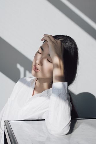 woman leaning on white table