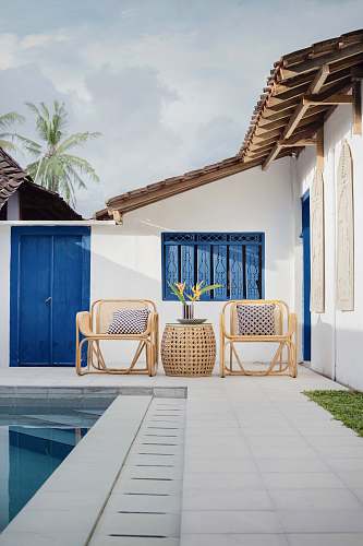  wicker table and two chairs near swimming pool 