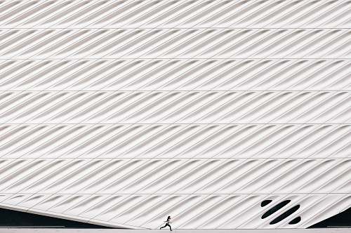 black-and-white person running near white painted wall texture