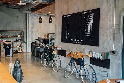 bicycle two bikes parked beside wall inside room coffee shop