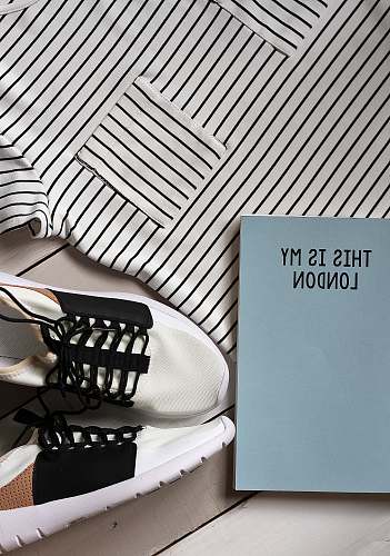 apparel pair of white-and-black sneakers beside book london