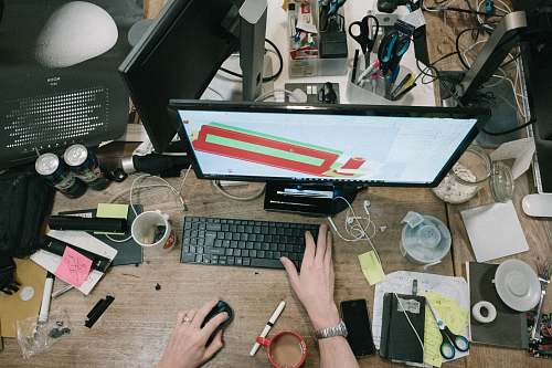 workspace person using computer on brown wooden table workstation
