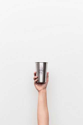hand person holding gray stainless steel drinking cup holding