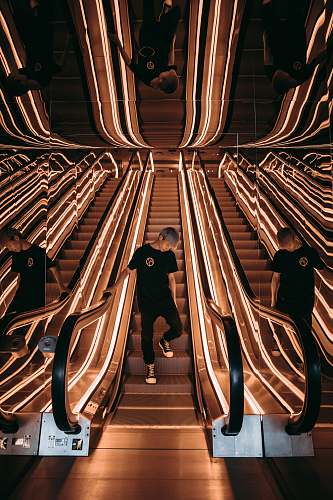 escalator man standing on escalator with string lights menswear
