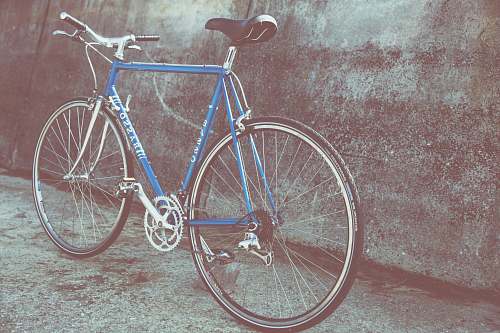 bicycle blue and gray rigid bicycle parked beside wall bike