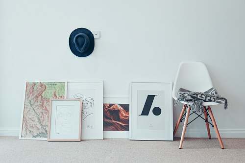 chair white chair beside five paintings furniture