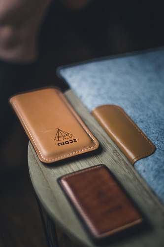 brown Leather laptop cover, wallet, and phone holder with a label that reads 