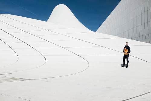 male man in black and orange jacket under blue sky modern