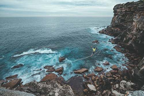 sea woman crossing the shore by balancing on the rope nature