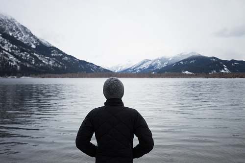 people man in black top standing in front of lake human