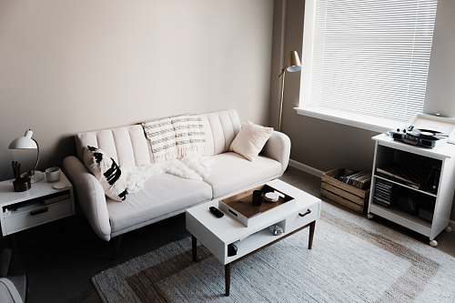 interior white couch in front of white wooden table home