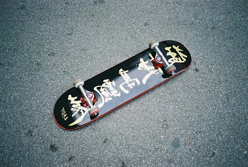 road black skateboard on gray surface trucks