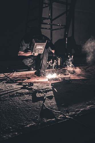 welder man welding black metal rubble