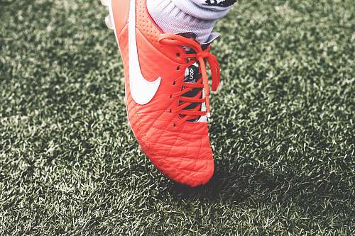 soccer unpaired orange and white Nike soccer cleat shoe
